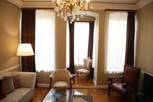 uma sala de estar com um sofá e um lustre em Agus Flats Galata em Istambul