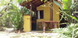 een open deur van een klein geel huis bij Pousada Aldeia de Morere in Moreré