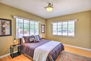 a bedroom with a large bed and two windows at Tranquil Tucson Home with Yard - Walk to U of A in Tucson