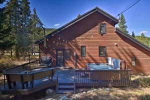 a log house with a hot tub and a deck at Cozy Blue River Cabin with Treehouse 6 Mi to Skiing in Blue River