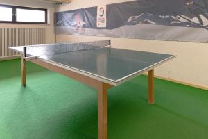 tavolo da ping pong in una stanza con pavimento verde di Huflattich a Obermaiselstein