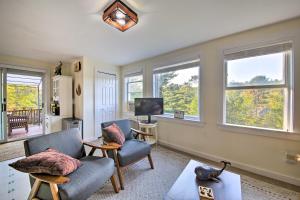 uma sala de estar com duas cadeiras e uma televisão e janelas em Boothbay Apt with Furnished Deck about 1 Mi to Bay em Boothbay Harbor