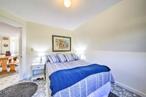 um quarto com uma cama com um cobertor azul em Boothbay Apt with Furnished Deck about 1 Mi to Bay em Boothbay Harbor