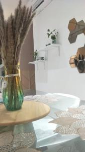 a vase with flowers in it sitting on a table at zara1881 muslim homestay@putrajaya in Putrajaya