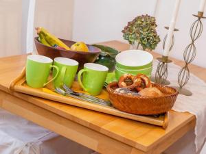 a tray with a basket of bread and cups on a table at Haus Koch-Lechner in Marquartstein +15 photos