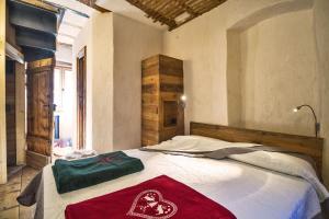 a bedroom with a bed with a red blanket on it at Maison La Saxe in Courmayeur