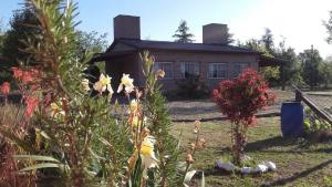 a house with a garden in front of it at Cabañas Hilario in Los Reartes