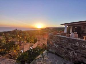 una puesta de sol sobre el océano desde una casa en Charming house with sea and mountain views in El Chaparral, en El Chaparral
