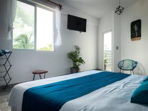 a bedroom with a large bed and two windows at Estancia del Agua in Xul-Ha