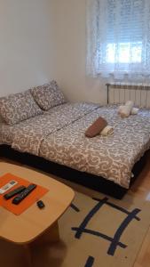 a bedroom with a bed and a coffee table at Sirmijum Hause in Sremska Mitrovica