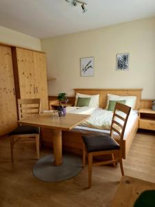 1 dormitorio con 1 cama, mesa y sillas en Frühstückspension Klein und Fein en Bad Hofgastein