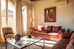 a living room with a red couch and a glass table at Apartamentos La Fonda in Cardona
