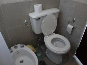 a small bathroom with a toilet and a sink at Cabañas Hilario in Los Reartes +11 photos