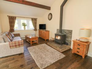 sala de estar con chimenea y sofá en Beckside Cottage, en Keighley