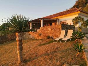 un grupo de sillas sentadas frente a una casa en Charming house with sea and mountain views in El Chaparral, en El Chaparral