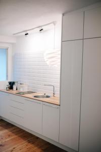 a kitchen with white cabinets and a sink at Ferienwohnung DOMizil Bamberg in Bamberg