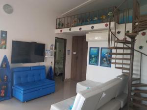 a living room with a blue couch and a staircase at San Andrés de Ensueño in San Andrés