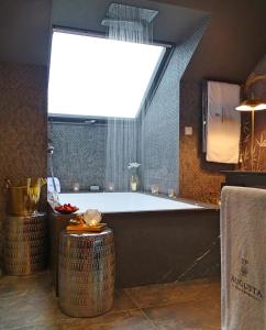Un baño grande con bañera y ventana. en Augusta Eco Wellness Resort 4 Superior, en Sanxenxo