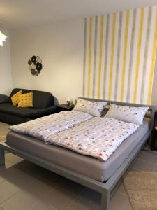 ein Bett in einem Wohnzimmer mit einem Sofa und einem Bett sidx sidx in der Unterkunft Studioapartment, nahe der Meinhardus-Schanze in Meinerzhagen