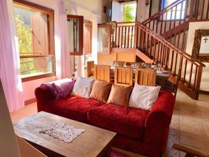 uma sala de estar com um sofá vermelho e uma mesa em Casa Guergue by VV Canary Ocean Homes em Masca