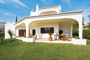 a white house with a table in a yard at Casa do Alvor in Alvor