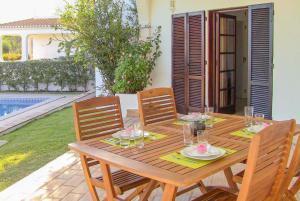 a wooden table with four chairs and a tableasteryasteryasteryasteryasteryasteryastery at Casa do Alvor in Alvor