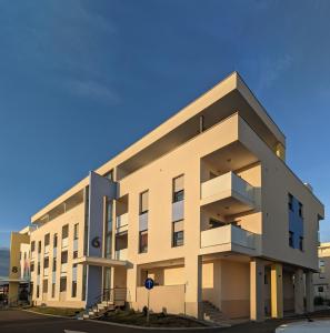 a large white building with balconies on a street at Blue Sky in Čakovec