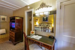 a room with a desk with a bed and a television at Mountainaire Inn and Log Cabins in Blowing Rock