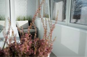 a vase of flowers in front of a window at Vytautas Park Apartment with FREE Parking in Marijampolė