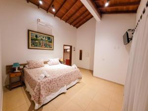 ein Schlafzimmer mit einem Bett in einem Zimmer in der Unterkunft Pousada Fazenda Peroba Rosa in Pedregulho