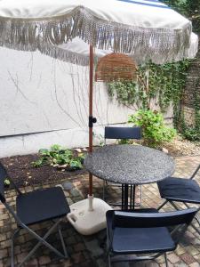 een tafel met twee stoelen en een parasol bij Boutique Apartment Scheldt in Antwerpen