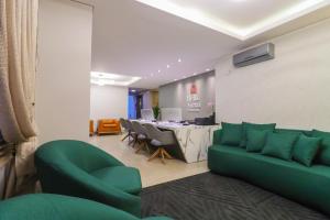 ein Wohnzimmer mit einem grünen Sofa und einem Tisch in der Unterkunft Pousada Bella Viena in Gramado