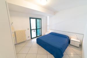 una camera da letto con un letto blu e una finestra di Le Pesche - Centro storico a Vasto
