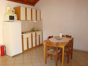 a kitchen with a table and a white refrigerator at Villas Oleandri in Vrboska