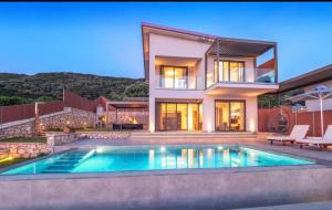 Mrs Grey Luxury Villa في ميغانيسي: بيت فيه مسبح قدام بيت
