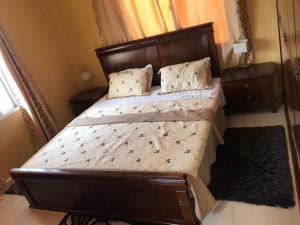 una camera con un grande letto con testiera in legno di Charming 2-Bed House in Brusubi a Brusubi