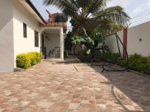 a patio outside of a house with a palm tree at Charming 2-Bed House in Brusubi in Brusubi