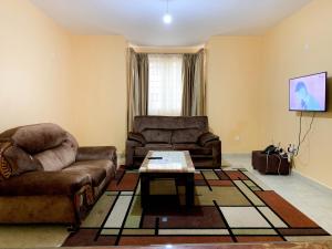 a living room with two couches and a coffee table at Easy Jkia Homestay in Nairobi
