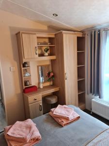 a bedroom with a desk and a bed with two towels at Nicks, next door to Carmels in Carnforth