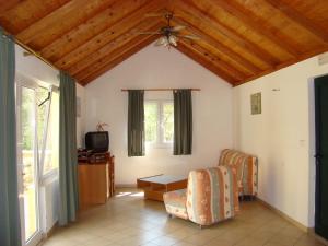 a living room with a ceiling fan and a tv at Villas Oleandri in Vrboska