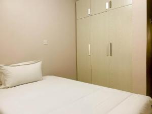 a bedroom with a white bed and a cabinet at Easy Jkia Homestay in Nairobi