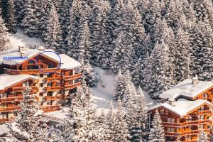 uma vista aérea de um hotel na neve em Le CAPRICORNE OLYMPIE 3 em Les Allues