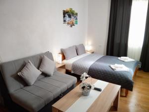 a hotel room with a couch and a bed at Holiday guest house KEMO in Sapareva Banya