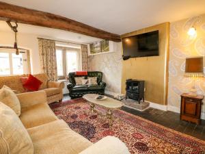 a living room with a couch and a fire place at The Farmhouse in Bakewell