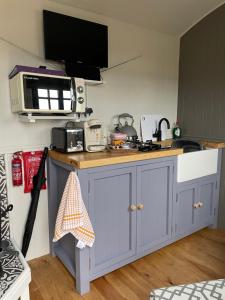 a kitchen with a counter top with a microwave at On the Moor Shepherds Huts in Bodmin