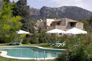 a villa with a swimming pool in front of a house at Hotel Rural Nou Dalt Muntanya in Orient