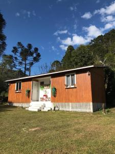 una pequeña casa con una naranja y blanco en Cabana Pé Da Serra dos Bitus, en Urubici
