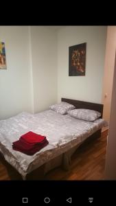 Bett in einem Zimmer mit rotem Hemd drauf in der Unterkunft Мост Сити in Dnipro