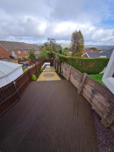 einen Garten mit Ziegelwand und Gehweg in der Unterkunft 3 Bed House with Garage, NR BPW & Brecon Beacons National Park in Cefn-coed-y-cymmer