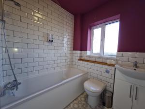 ein Badezimmer mit Badewanne, Toilette und Waschbecken in der Unterkunft 3 Bed House with Garage, NR BPW & Brecon Beacons National Park in Cefn-coed-y-cymmer + 9 Fotos